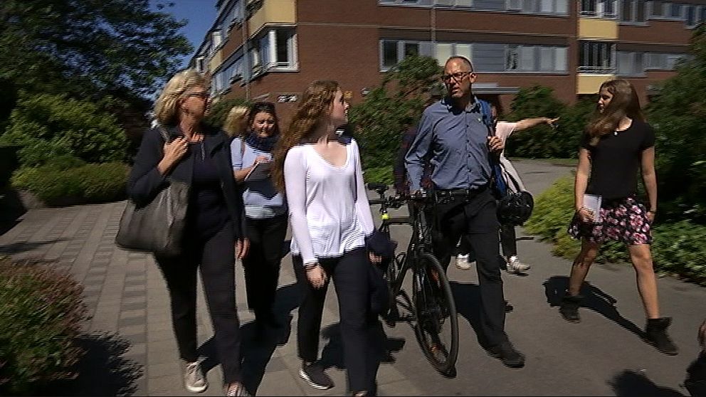 En grupp människor går genom ett bostadsområde.