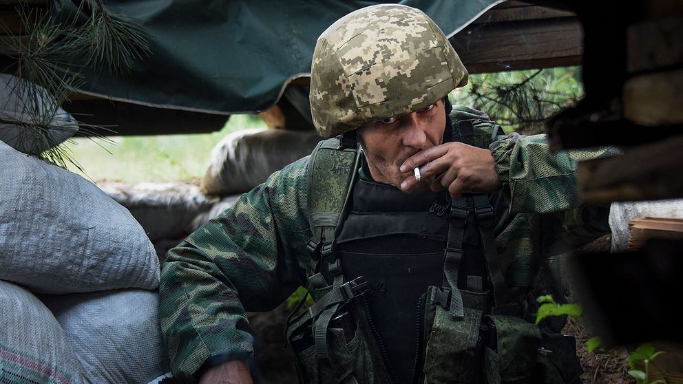 En ryskstödd separatist röker i en skyttegrav nära Marinka i Donetsk i östra Ukraina. (Arkivbild)