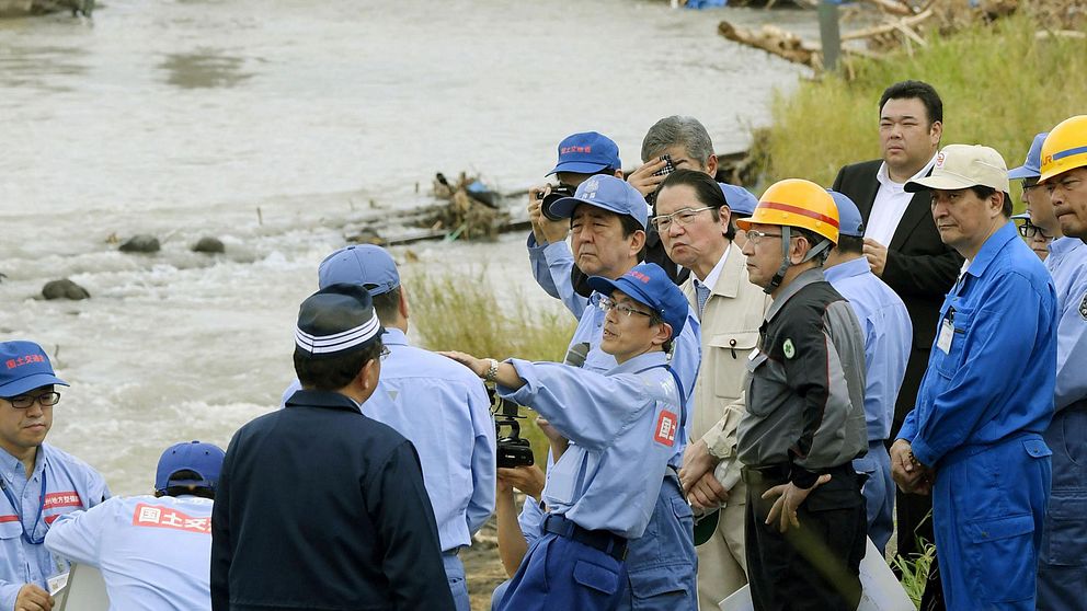 Japans premiärminister Shinzo Abe inspekterar skadorna efter skyfallen i södra Japan.