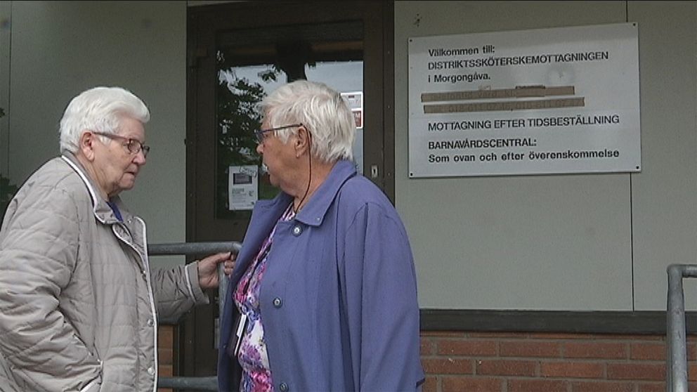 Två äldre kvinnor står utanför den stängda distriktssköterskemottagningen i Morgongåva, Heby kommun.