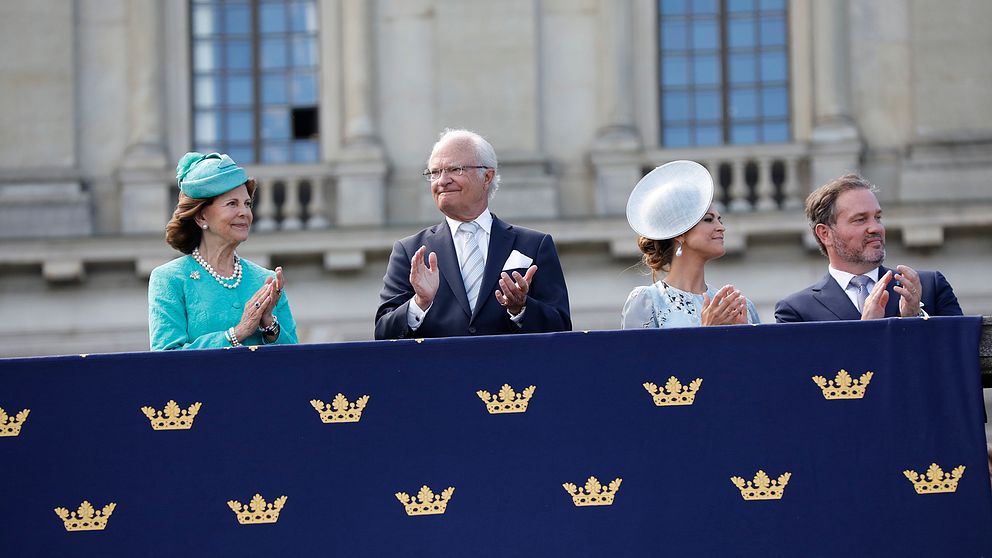 Drottning Silvia, kung Carl Gustaf, prinsessan Madeleine och Christopher O'Neill ser på födelsedagskortegen från Logården.