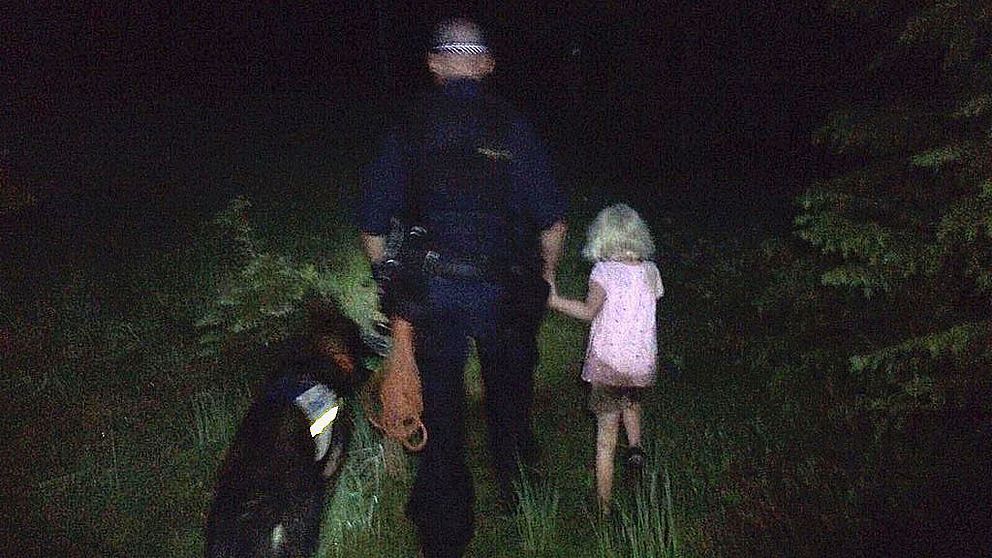 Hundföraren, polishunden Attack samt flickan sedd bakifrån när de går genom skogen.