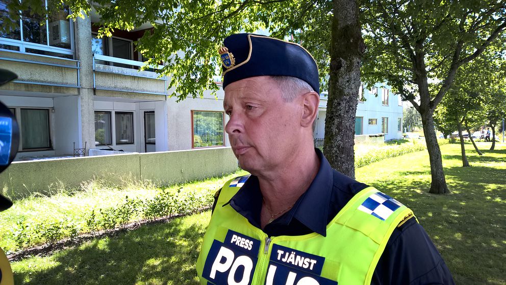 Polis framför byggnad.