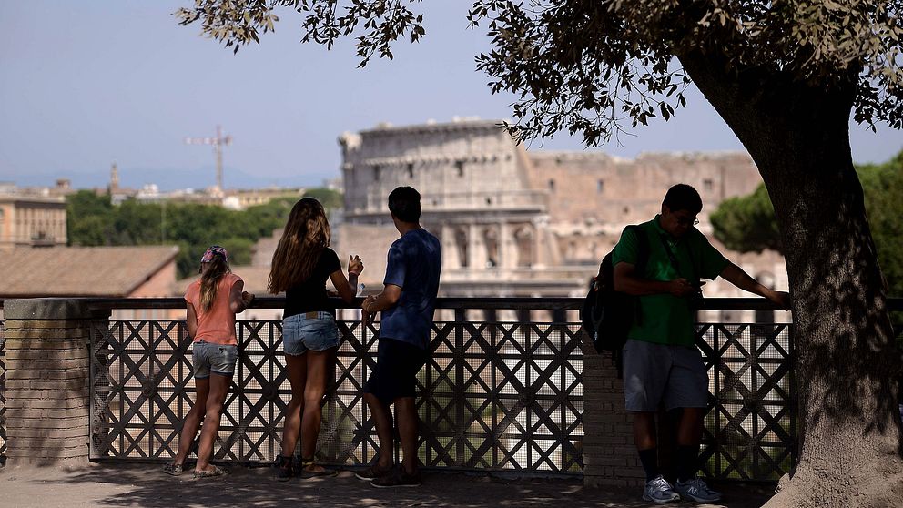 Turister tittar på Colosseum i Rom.
