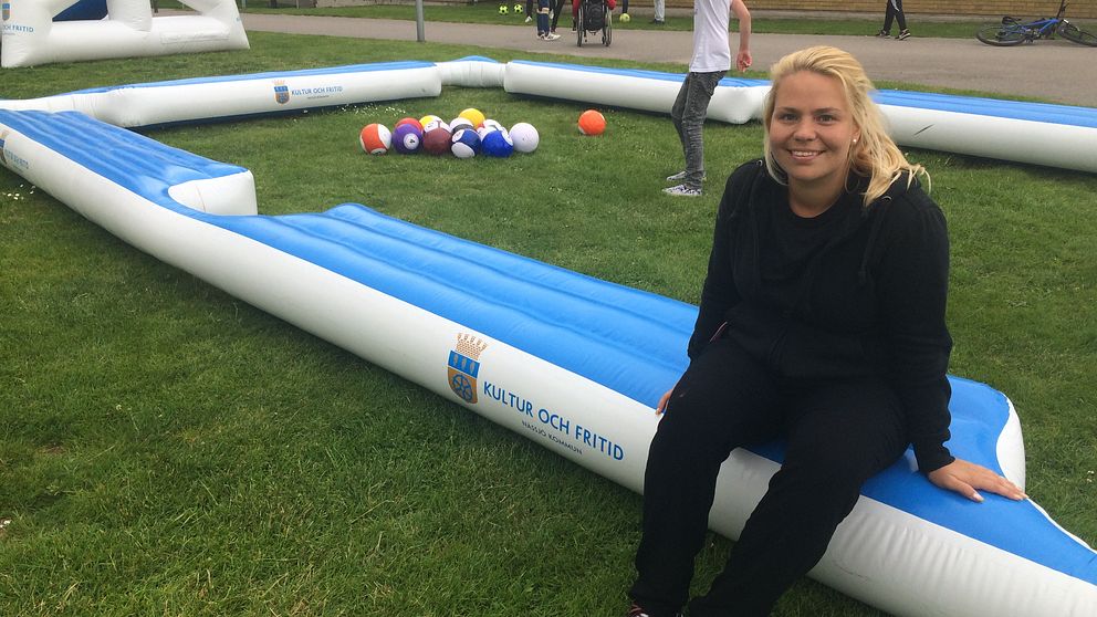 Emma Asserholt sitter på uppblåsbar fotbollsbiljard
