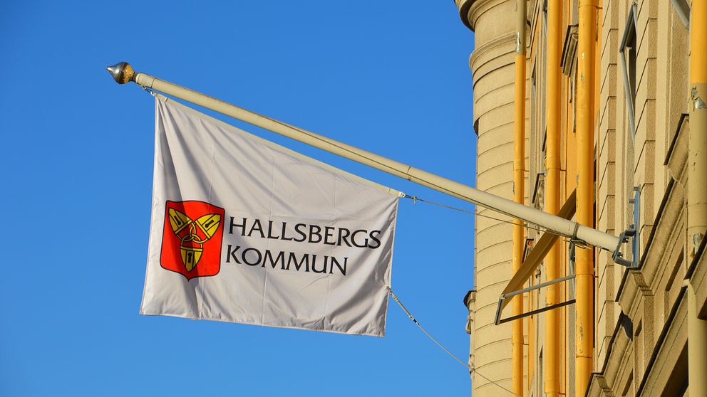 Flagga med Hallsbergs kommunvapen och texten Hallsberg kommun.