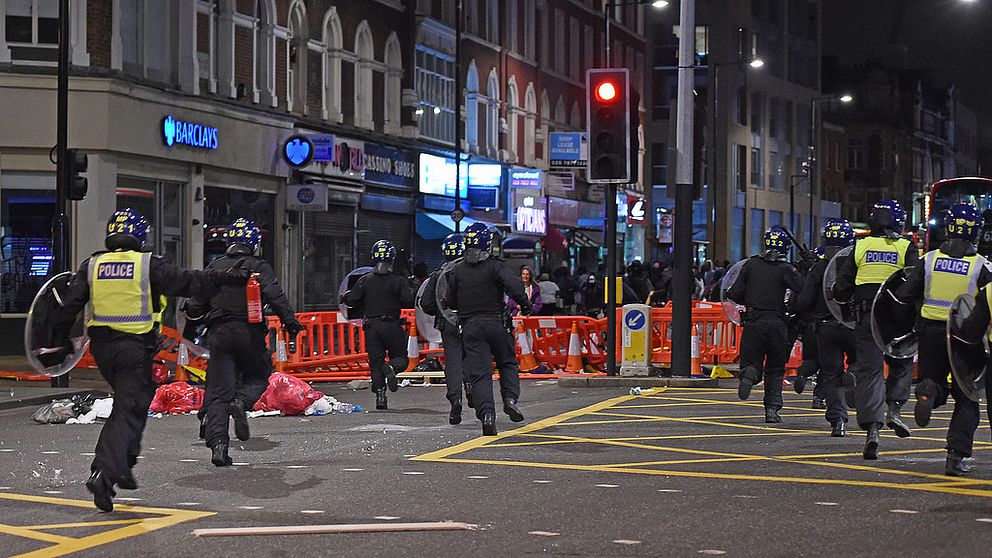 Kravallpolis springer på gata i London.