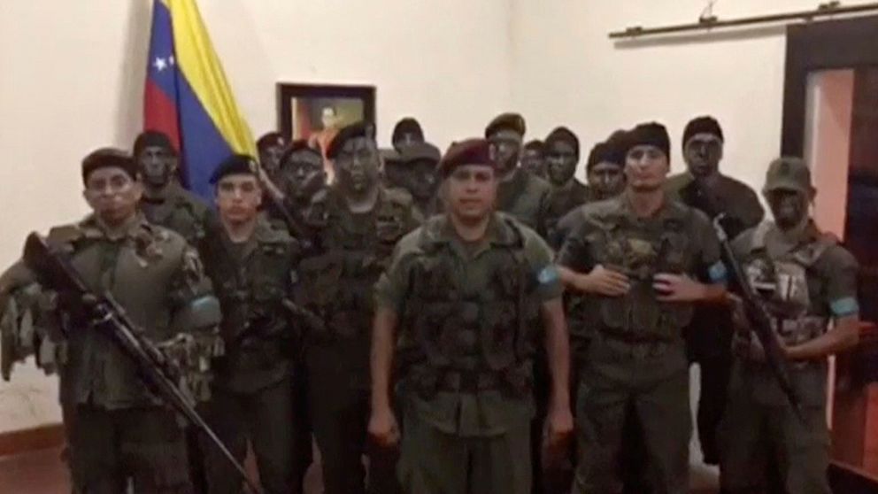 En bild från videon, där en grupp män i militäruniformer säger att de har inlett ett uppror i delstaten Carabobo där Valencia ligger.