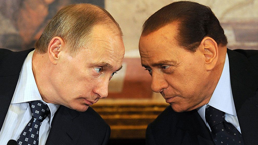 Rysslands president Vladimir Putin lutar sig mot Italiens förre premiärminister Silvio Berlusconi