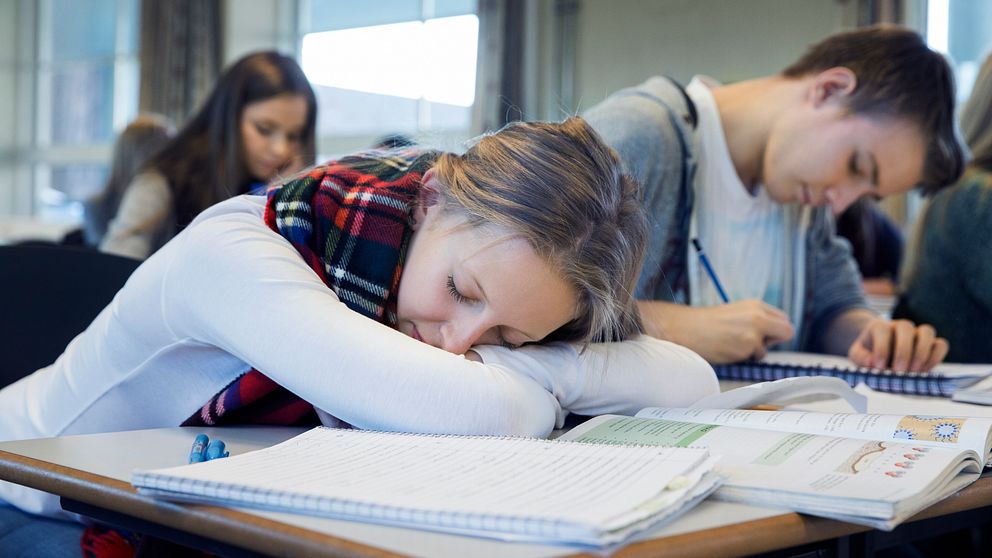 Ett skolbarn ser ut att sova på sina skolböcker
