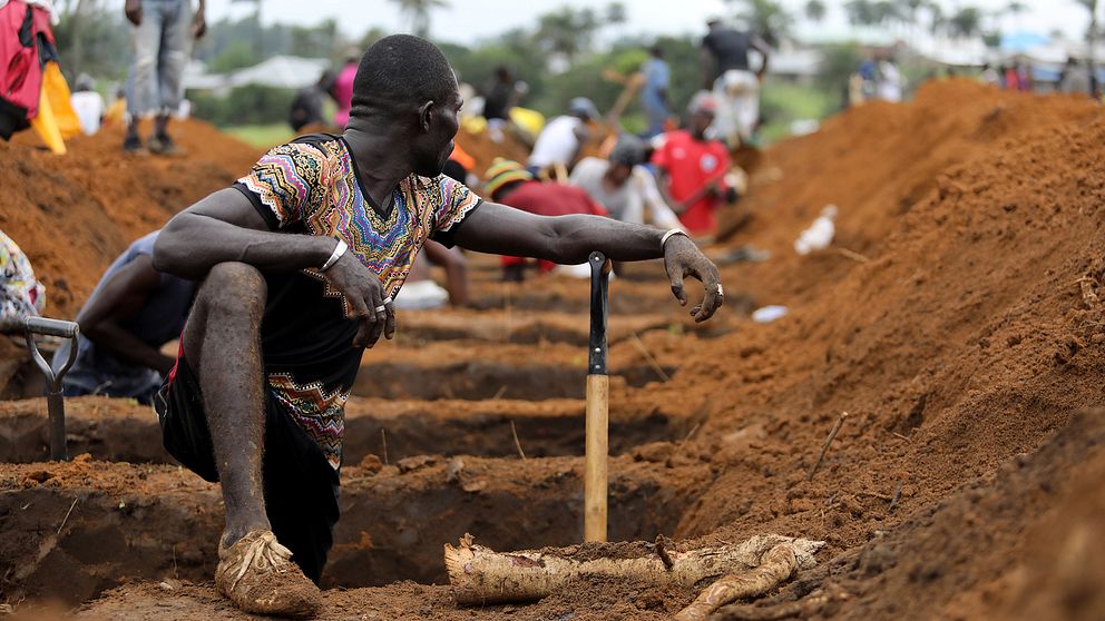 En volontär gräver gravar åt offren i lerskredet den 14 augusti.