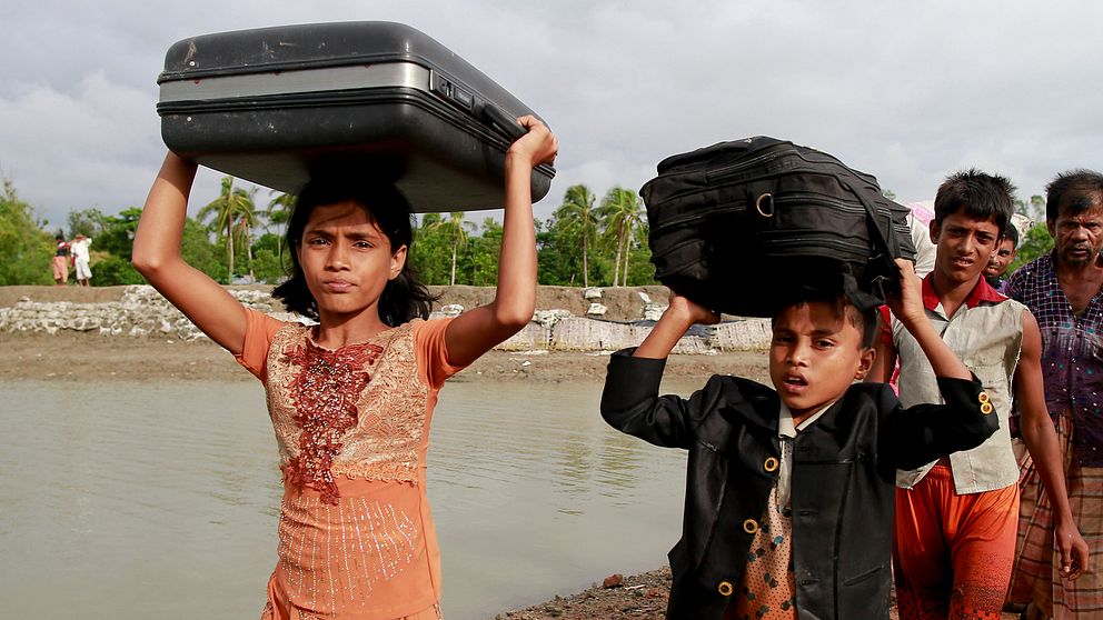 Två rohingyabarn på flykt bär sina tillhörigheter i Teknak, Bangladesh.