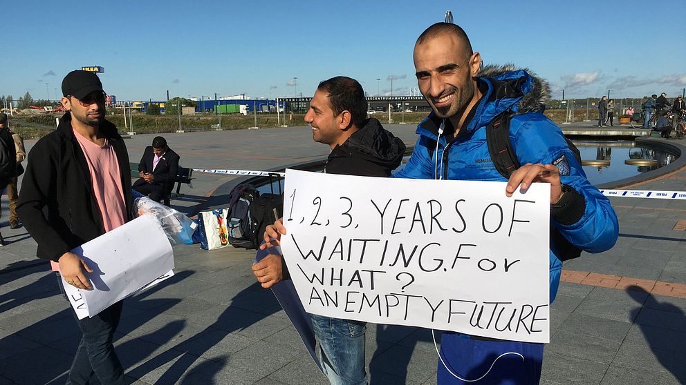 Tre demonstranter med plakat