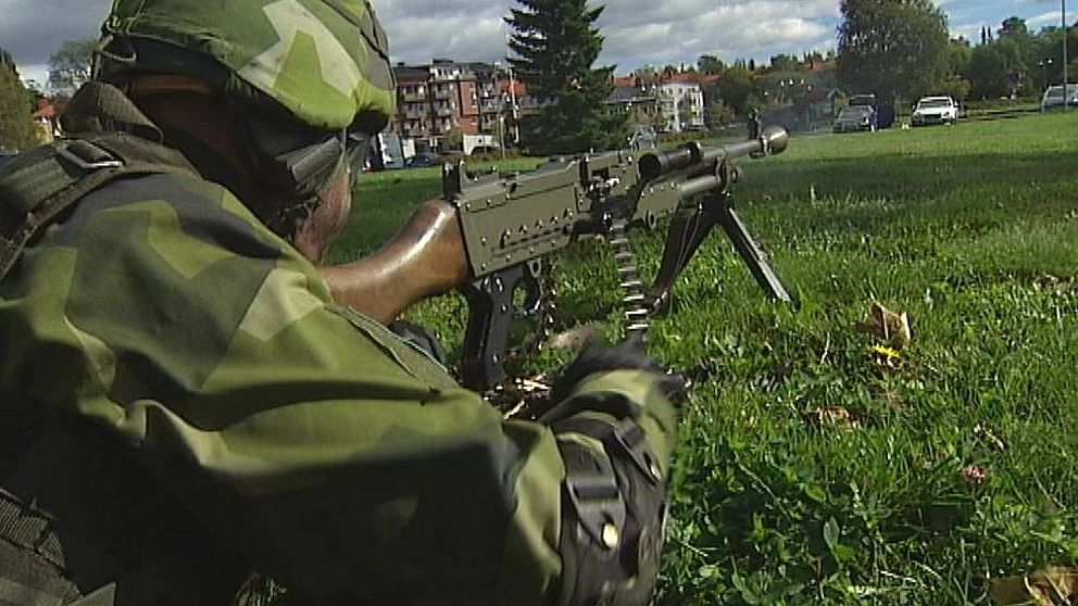 Soldat med vapen i stadsmiljö