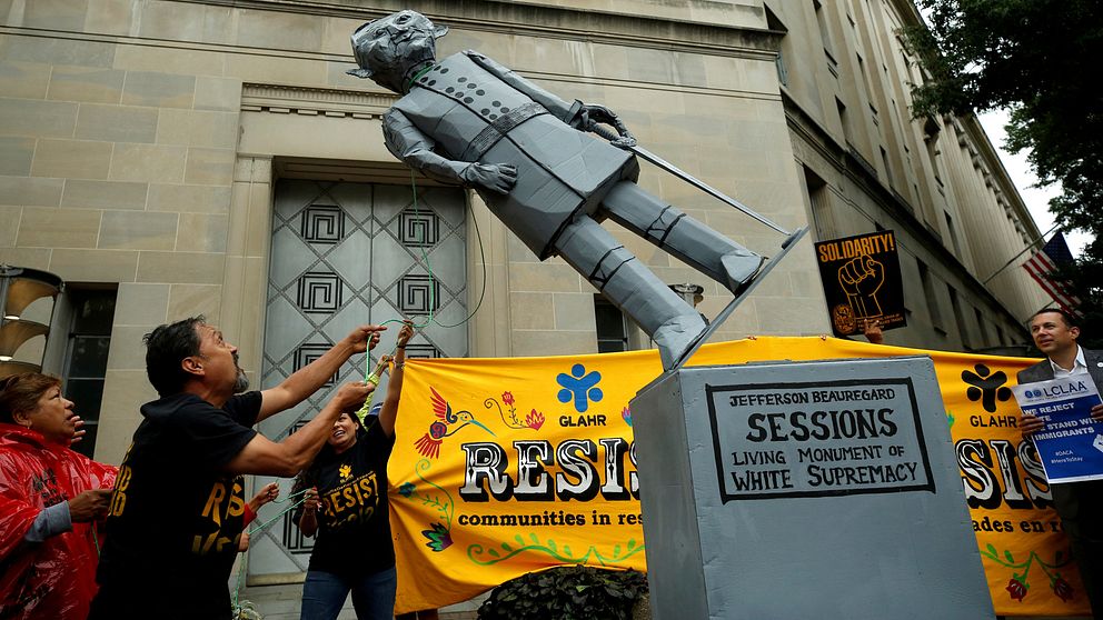 Aktivister drar ner staty på Jeff Sessions utanför justitiedepartmentet i Washington.