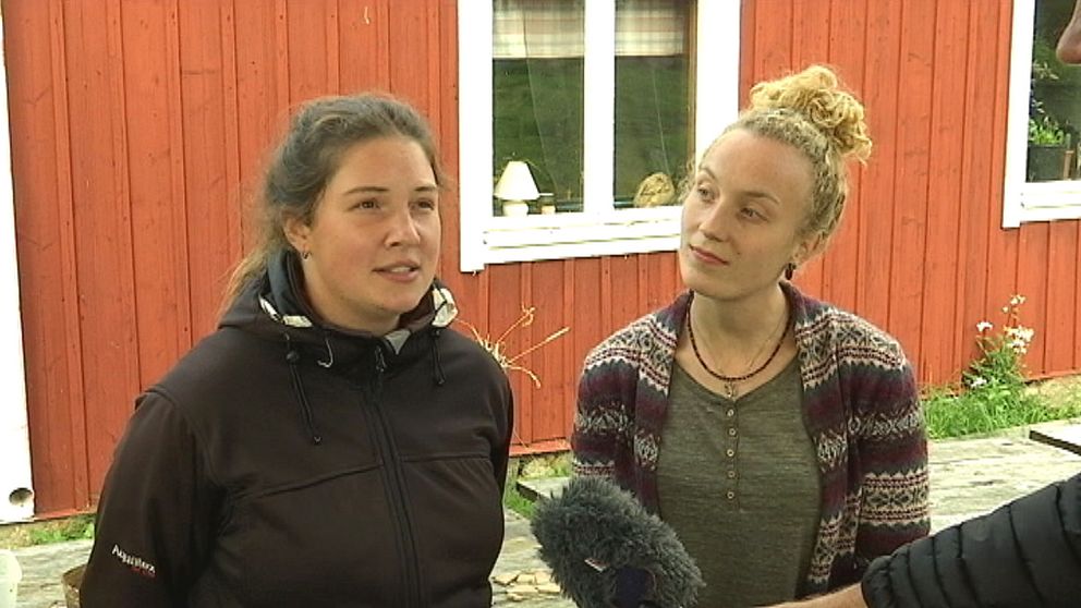 två tjejer framför falurött hus