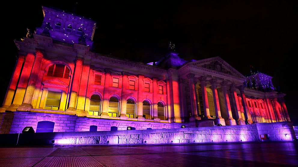Förbundsdagsbyggnaden i Berlin upplyst i tyska flaggans färger.