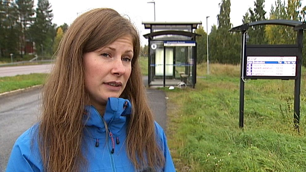 Kvinna intervjuas vid busshållplats.
