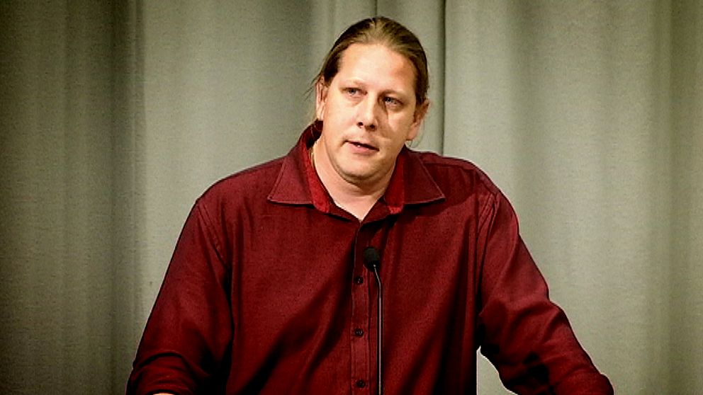 Patrik Liljeglöd (V) står i en talarstol och talar i en mick.