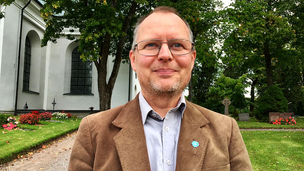 Johnny Grahn står i mitten av bilden iklädd brunkavaj med en SD-blomma på bröstet.