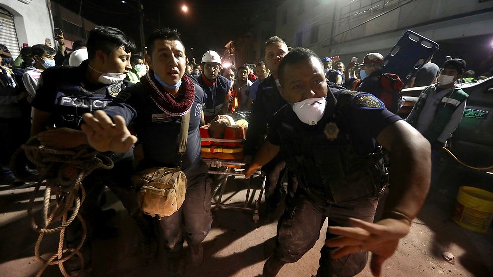 Räddningsstyrkor i Mexico City hjälper en människa som skadats i jordbävningen.