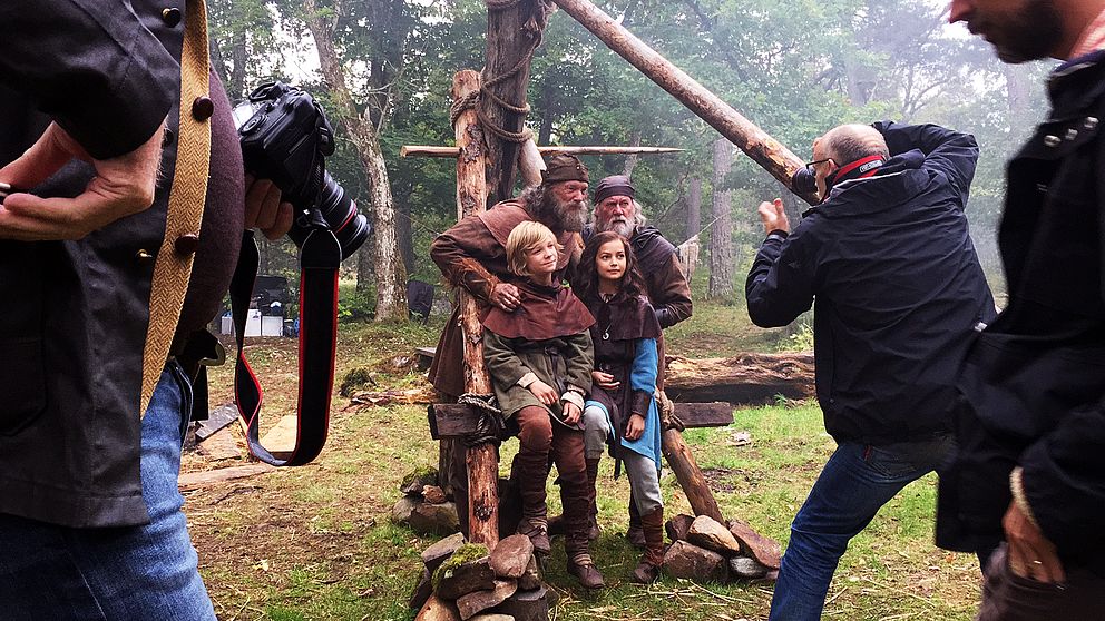 Fyra skådespelare i vikingakläder fotograferas av två fotografer