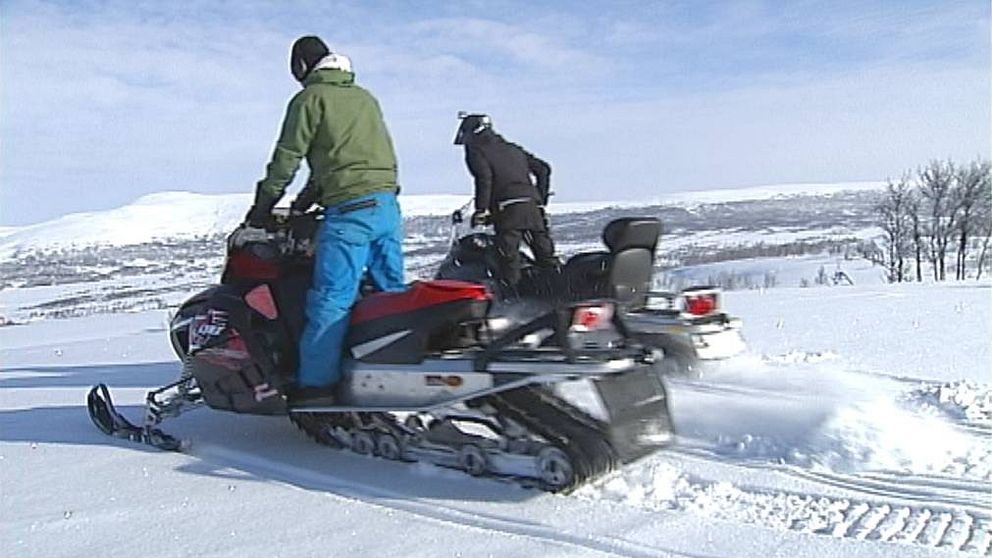 två personer på skotrar på kalfjället