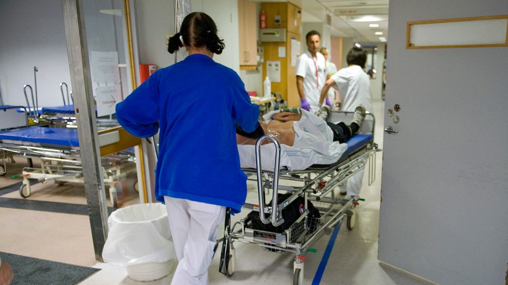 Vårdpersonal springer med en person som ligger på en sjukhussäng.