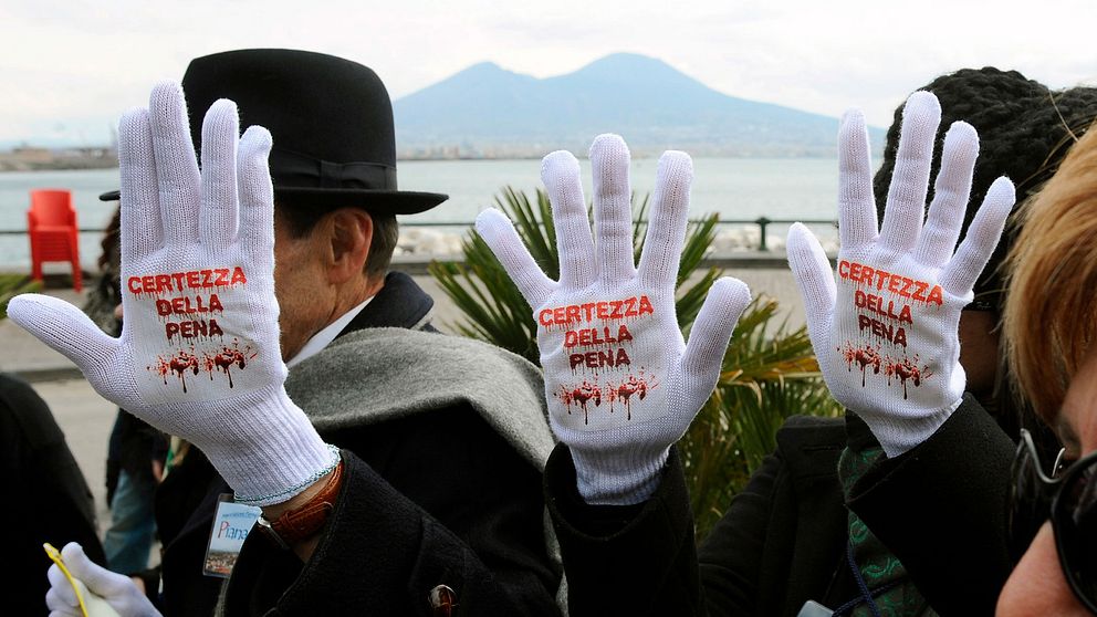 Medlemmar i organisationen Libera demonstrerar mot maffians våldsvälde i Neapel 2009. På vita handskar står i teaterblod ”säkra på straff”.