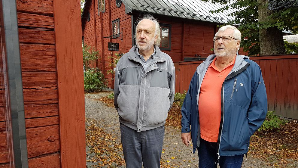 Curt Fröberg och Kenneth Löfgren  tittar på en av skyltarna i den nya utomhusutställningen i Wadköping.