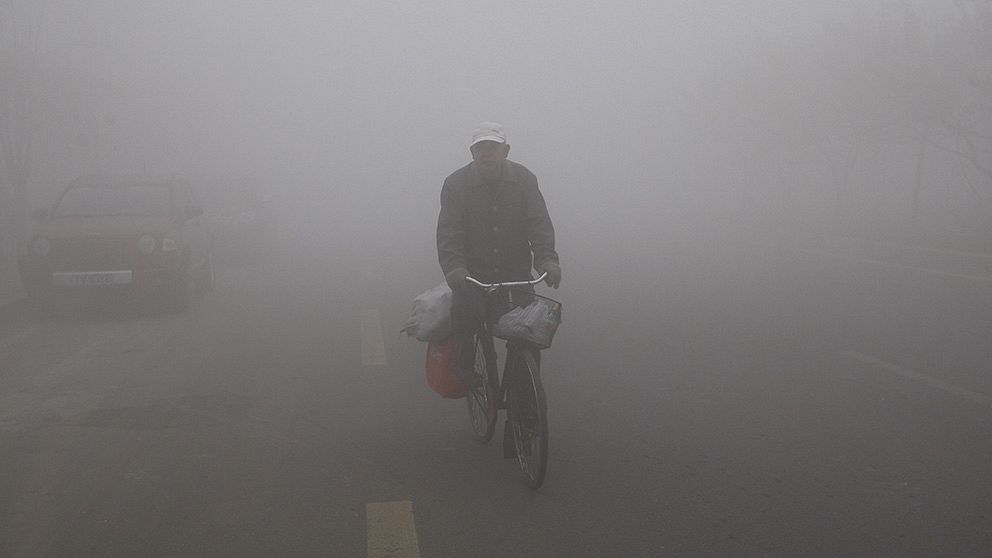 En cyklist navigerar genom smogen i Harbin