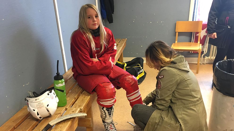 Alma Bååth, Nora HC, får hjälp med skridskorna.