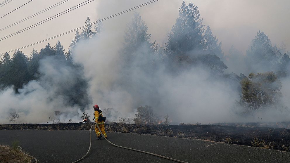 En brandman jobbar med att släcka branden i närheten av  Oakmont i Santa Rosa, Kalfornien.