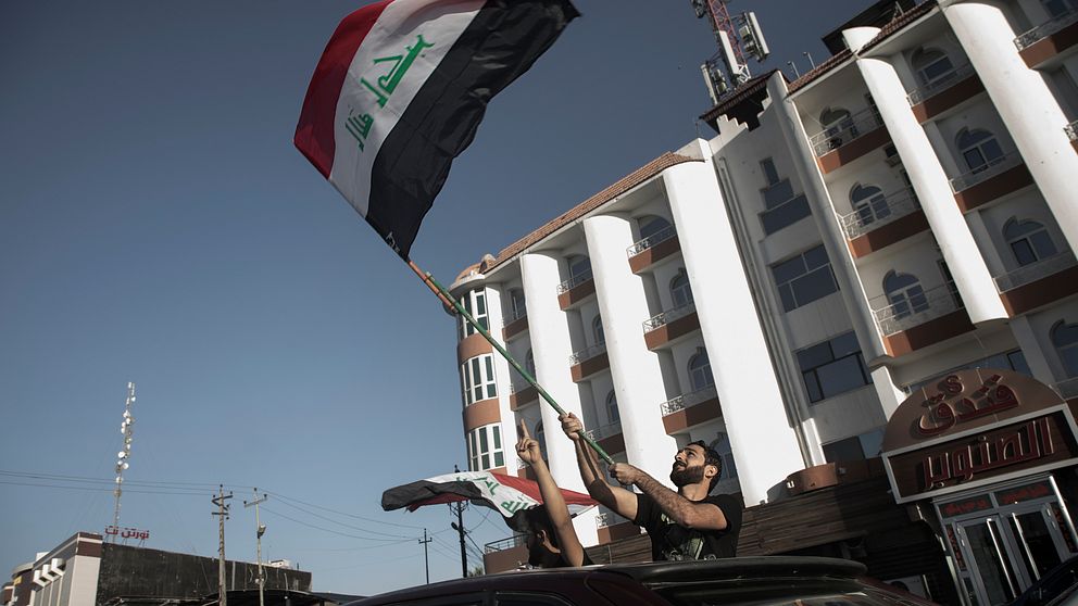 Män med irakiska flaggor