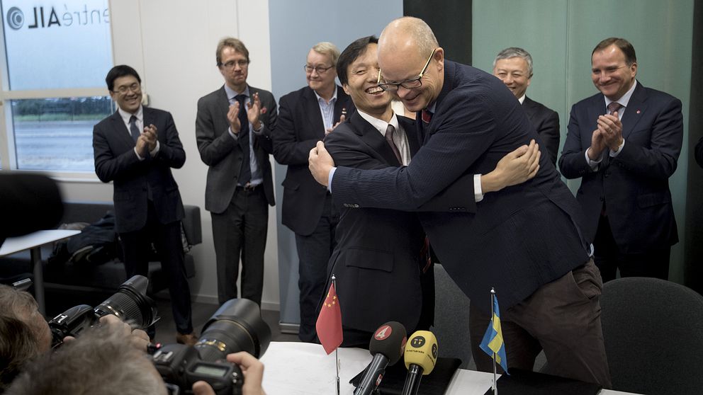 Aries Liu, vd Automative alliance didi och Nevs vd Stefan Tilk kramar artigt varandra vid en presskonferens.