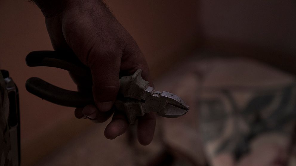 Med en skakig hand knipspar en av de irakiska soldaterna av tråden som ska utlösa sprängmedlet.