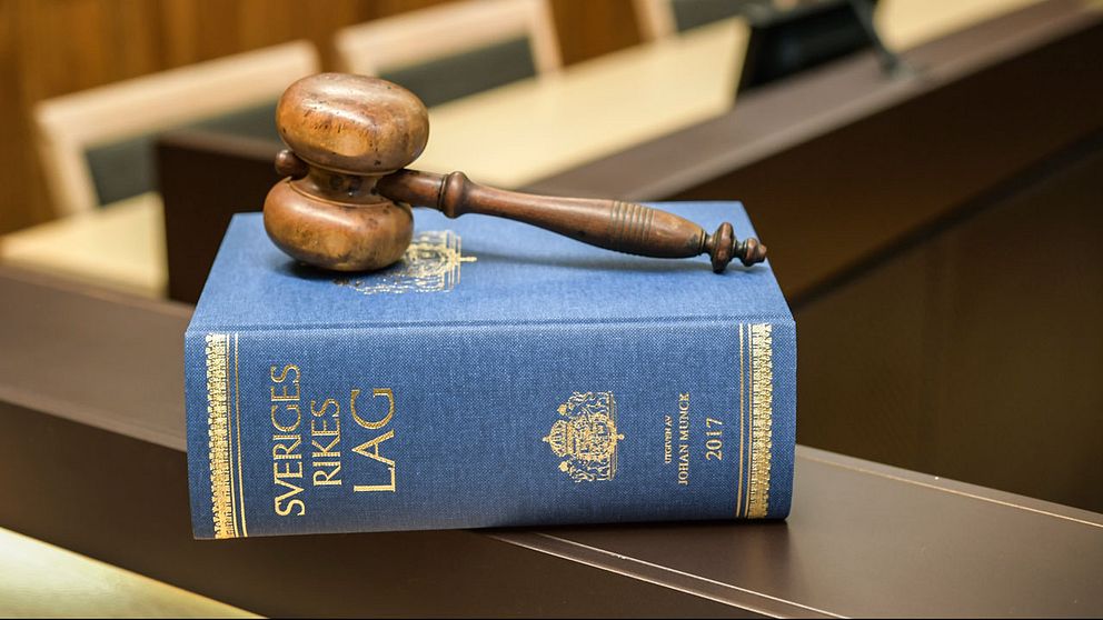 Domstolsklubba liggandes på lagbok i rättssal