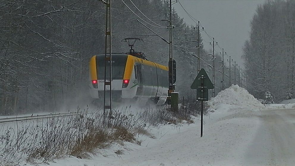 Ett tåg, snön yr bakom det.