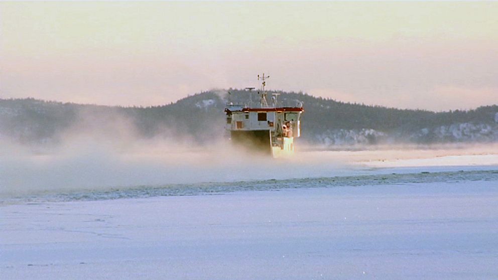 En båt stävar över rykande vinterhav.