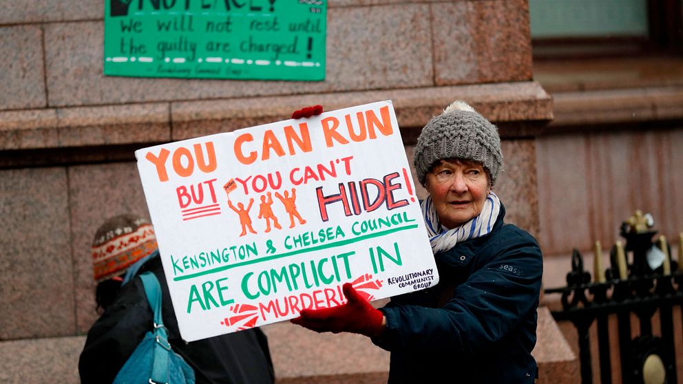 En kvinna bär en skylt med texten: You can run but you can´t hide!