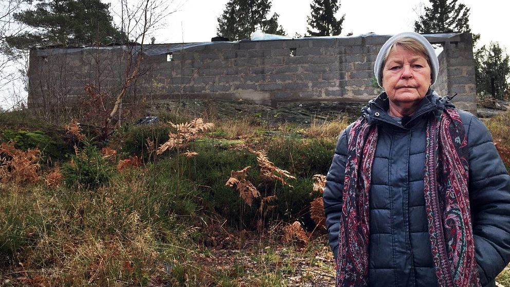 Kvinna står framför en murad husgrund