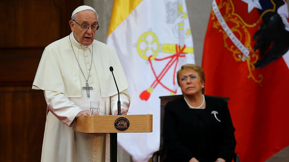 Påve Franciskus talar i Chiles huvudstad Santiago under tisdagen. Till höger Chiles president Michelle Bachelet.