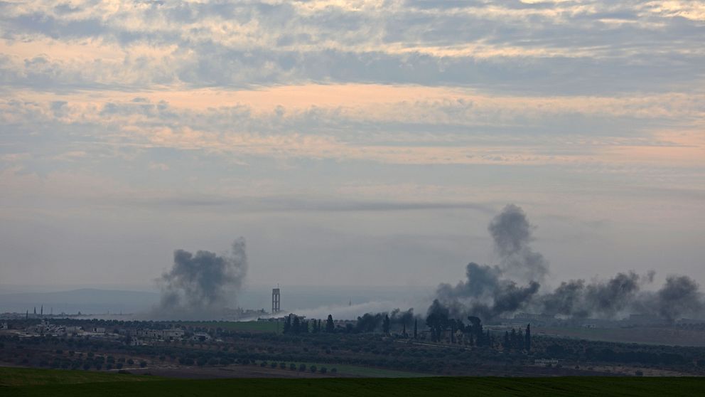 Rökmoln från flygbomber stiger från flera platser i en stad i syriska provinsen Idlib.