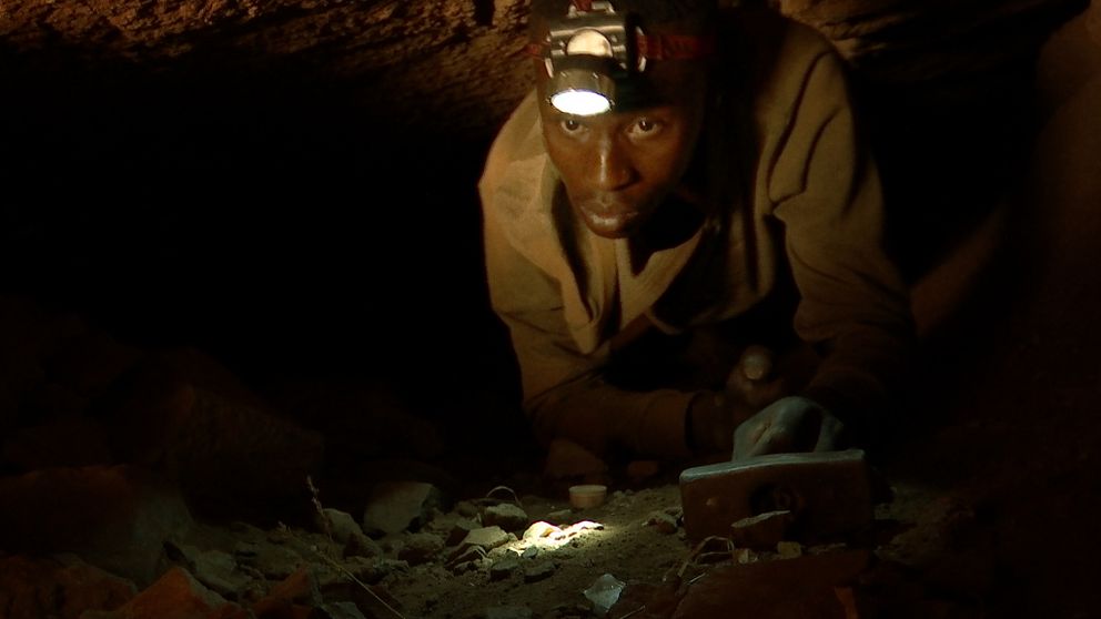 En man med pannlampa i en gruvgång i Sydafrika.