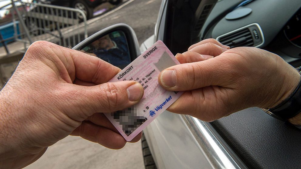 En person tar ifrån en förare sitt körkort.