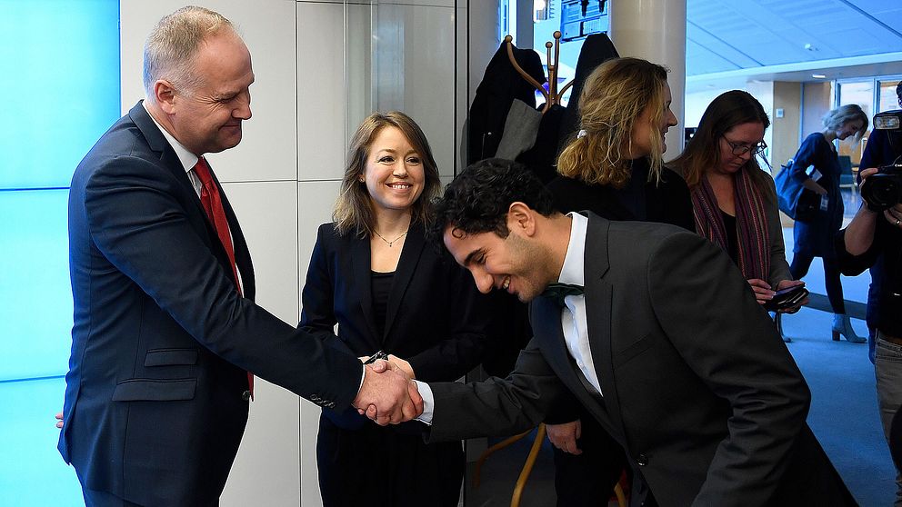 Jonas Sjöstedt tar Ardalan Shekarabi i hand inför presskonferensen i dag.