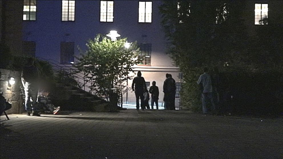 Silhuetter av personer som står utomhus vid ett torg i Stockholm.