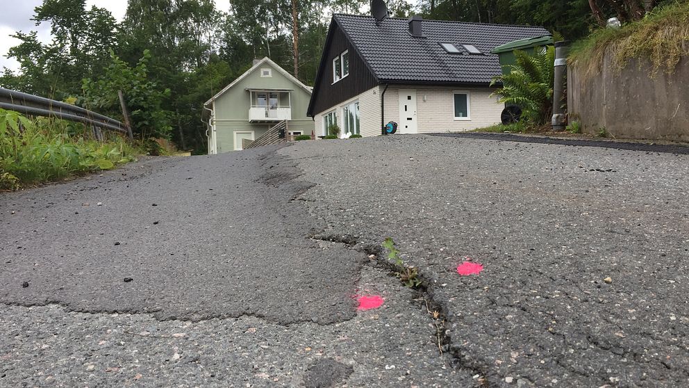 närbild på spricka i asfalt, markerad med två rosa prickar
