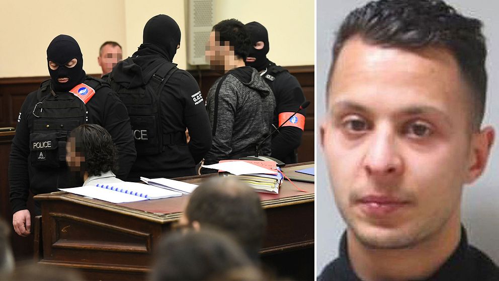 Maskerade poliser framför Salah Abdeslam i rättssalen i Bryssel.