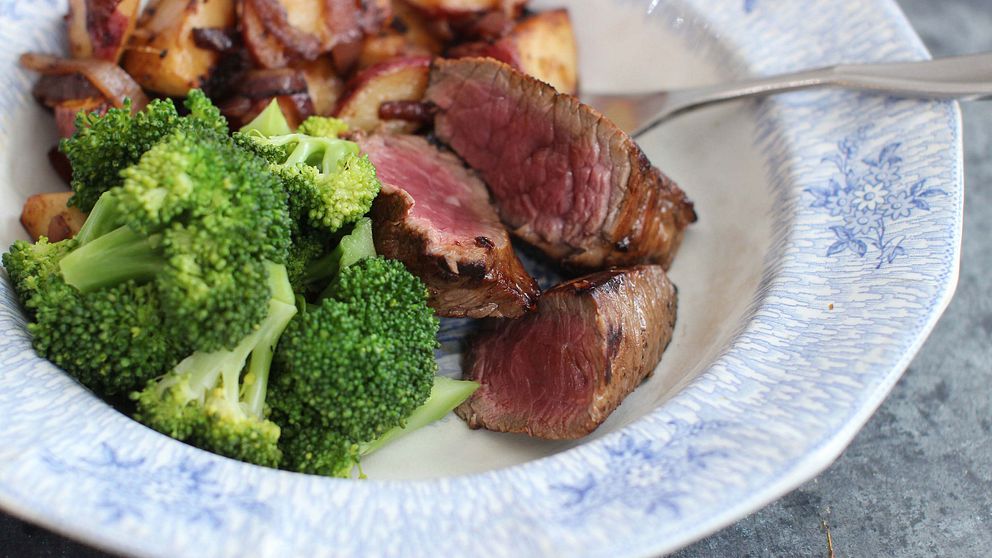 En tallrik med kött och broccoli